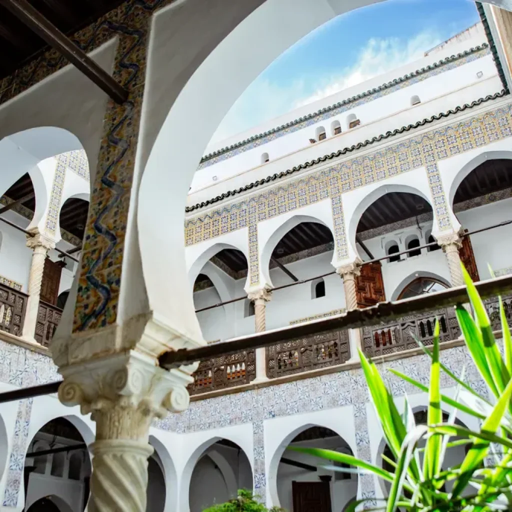 Cour intérieure d'une maison traditionnelle de la Casbah d'Alger, arcades blanches et végétation