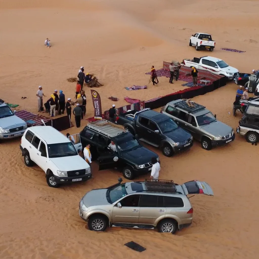 Excursion en 4x4 dans les dunes du désert, véhicules et voyageurs rassemblés sur le sable