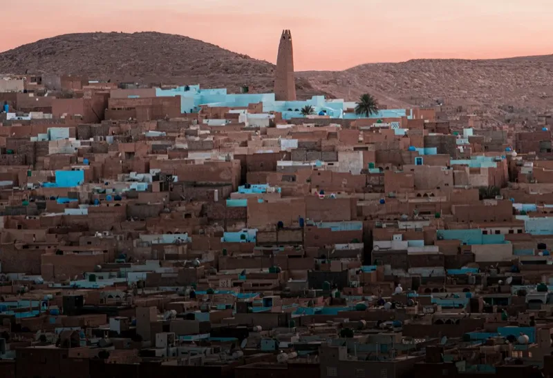 Vue panoramique de Ghardaïa au coucher du soleil avec son minaret et ses maisons colorées
